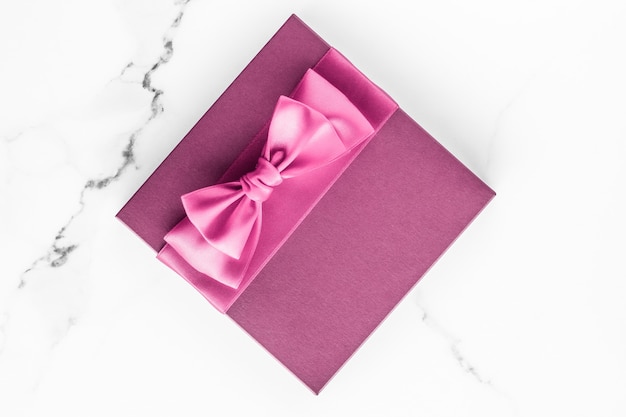 Matrimonio di compleanno e concetto di branding femminile scatola regalo rosa con fiocco di seta su superficie di marmo regalo di baby shower per ragazza e regalo di moda glamour per il design di arte flatlay di vacanza del marchio di bellezza di lusso