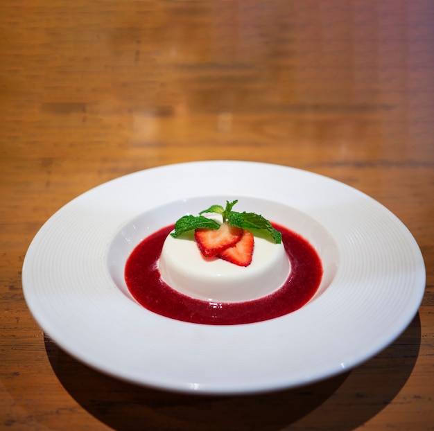 Foto bisconsaus van panna cotta van de close-up in een witte plaat