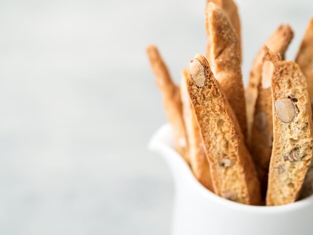 Biscotti (cantuccini) - traditioneel Italiaans amandeldessert in witte kopclose-up.