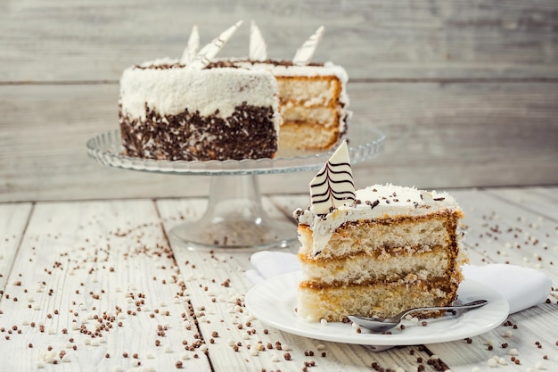 Biscuit cake with caramel and chocolate on a wooden background