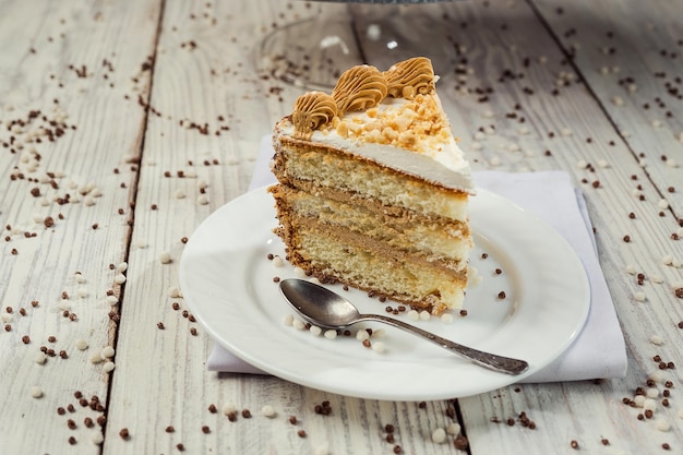 木製の背景にチョコレートクリームとチェリーとビスケットケーキ