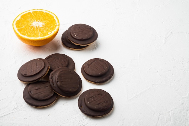 Biscuit gevuld met sinaasappel, gegarneerd met chocolade set, op witte stenen tafel achtergrond, met kopie ruimte voor tekst