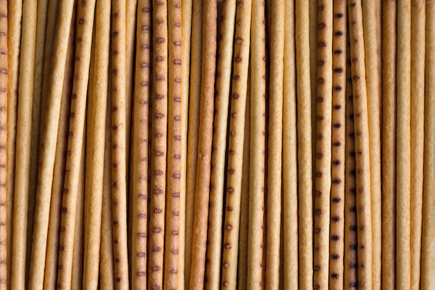 Biscuits in the form of long thin straws of yellow and brown color