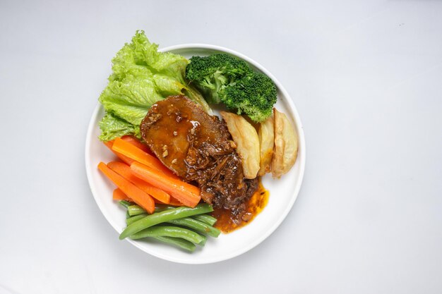 Photo bistik lidah sapi or tounge beef steak served with barbecue sauce and vegetables
