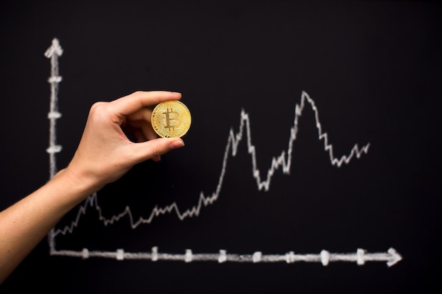 Bitcoin-afbeelding met pijl omhoog op blackboard als cryptocurrency online handelswaarde groeiend concept Hand met bitcoin