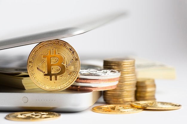 Foto bitcoin e pila di banconote sul computer portatile defocused