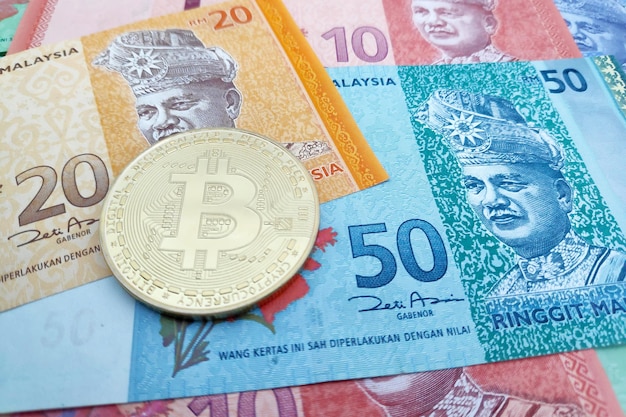 Bitcoin bovenop een stapel Maleisische Ringgit-bankbiljetten