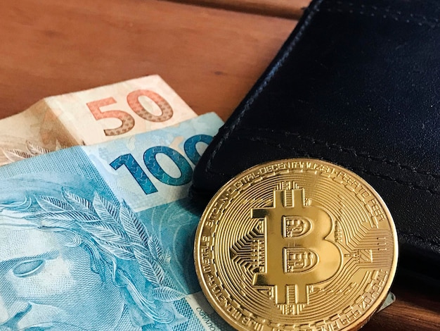 Bitcoin Brazilian money and wallet on wooden table