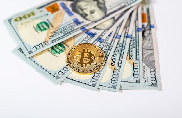 Bitcoin or BTC golden coin with sign of cryptocurrency on banknotes of us dollar