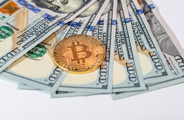 Bitcoin or BTC golden coin with sign of cryptocurrency on banknotes of us dollar