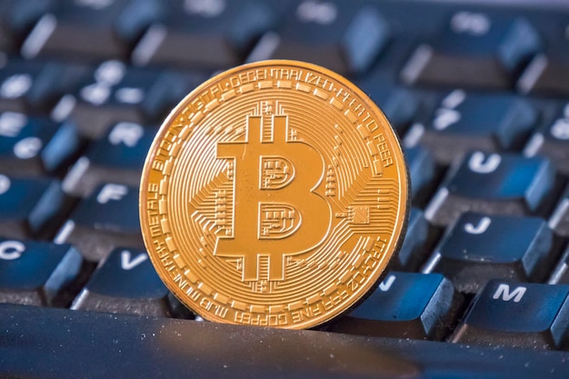 Bitcoin coin over black keyboard