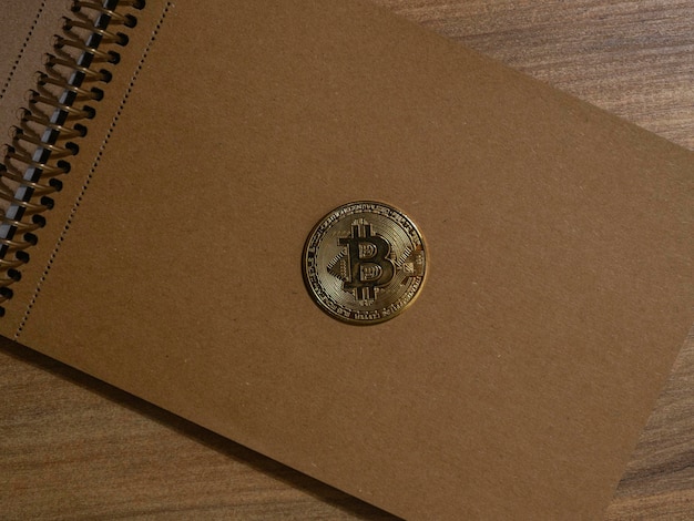 Биткойн-монета на винтажном блокноте