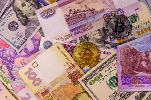 Bitcoin coins on the american, ukrainian and russian banknotes