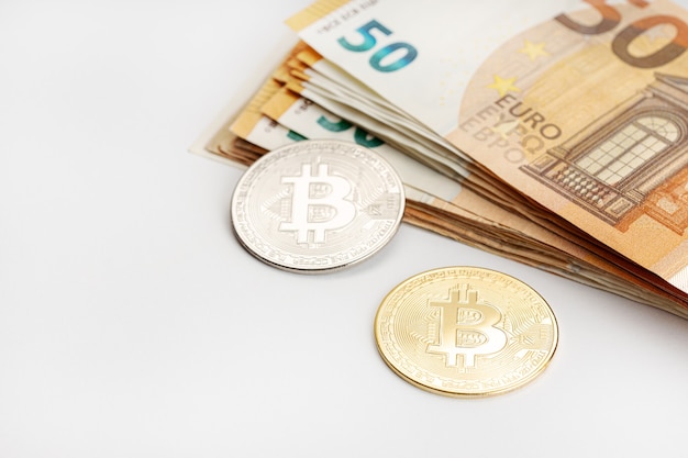 ビットコインコインとユーロ紙幣。暗号通貨と法定紙幣の概念