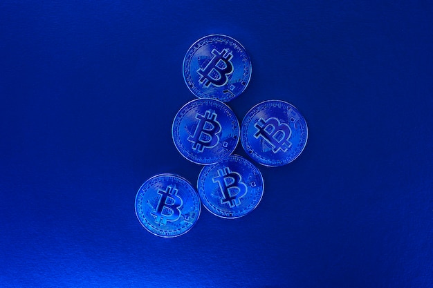 Un bitcoin monete con luce blu sulla parete blu. criptovaluta