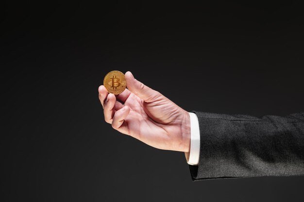 Photo bitcoin cryptocurrency trader offering a golden coin selective focus