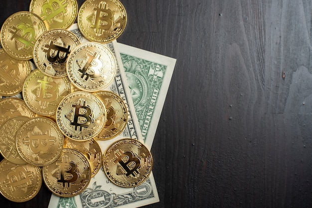 Bitcoin and dollar money on wooden desk