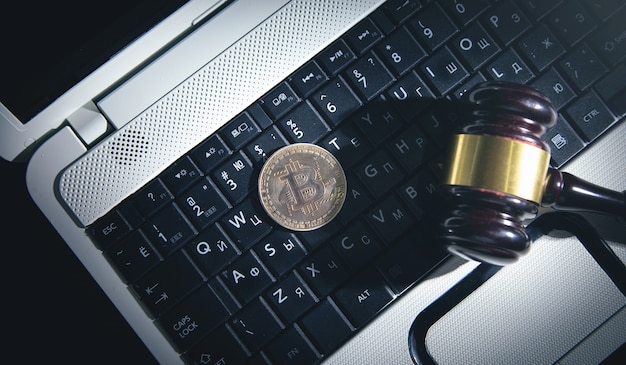 Bitcoin en hamer op het toetsenbord van de laptop.