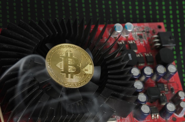 A bitcoin gold coin on a cooling fan in smoke. Selective focus.