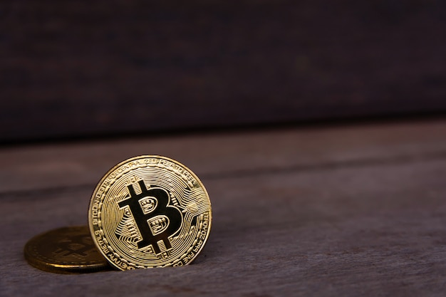 Moneta d'oro bitcoin su legno scuro con copyspace