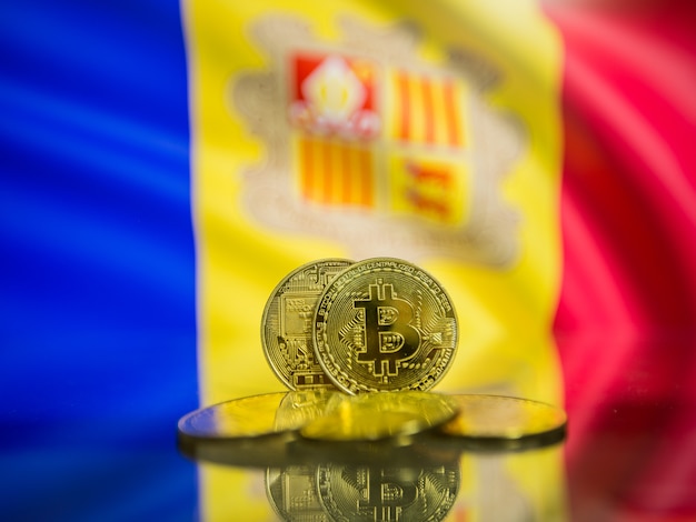 Bitcoin gold coin and defocused flag of Andorra background. Virtual cryptocurrency concept.