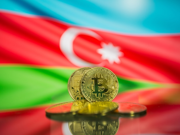 Bitcoin gold coin and defocused flag of Azerbaijan background. Virtual cryptocurrency concept.