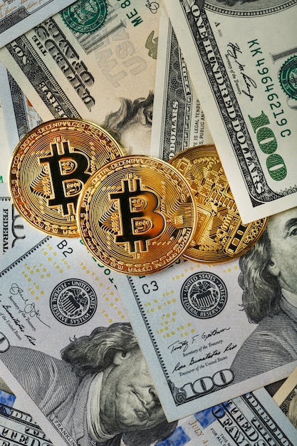 Золотые монеты bitcoin на долларовых купюрах сша