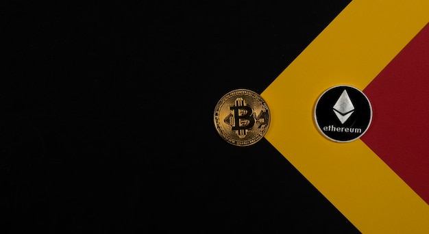 Photo bitcoin golden coin and ethereum silver on black background with copy space for text.