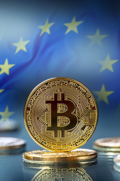 Bitcoin. Golden and silver bitcoins - virtual cryptocurrency.  Flag of european union in the background