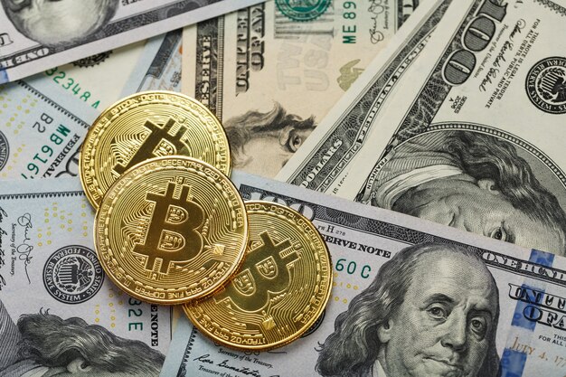 Bitcoin gouden munten op Amerikaanse dollarbiljetten