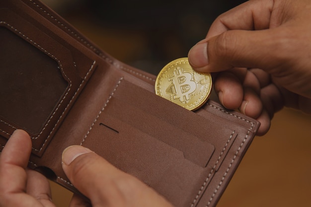 Bitcoinはビジネスマンの手に財布を着ています。