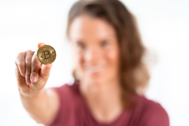 Bitcoin in de hand van een jonge vrouw die op witte achtergrond wordt geïsoleerd