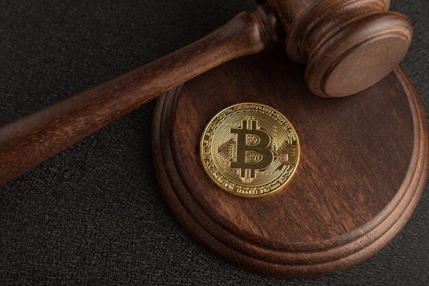 Bitcoin and judge gavel. Cryptocurrency legislation. Close up. Violation of law.