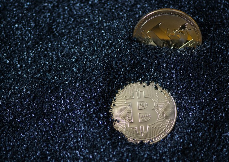 Photo 比特幣和萊特幣在藍色閃<unk>粒子上,沙子. 電子貨幣