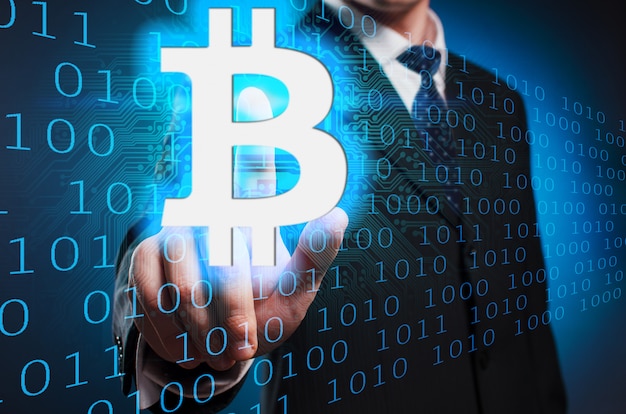 Bitcoin. A man in a suit and tie clicks the index finger on the virtual screen.