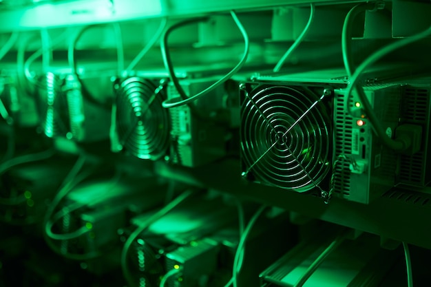 Bitcoin miners in large farm asic mining equipment on stand
racks mine cryptocurrency in steel container blockchain techology
application specific integrated circuit rig server room lights and
fans