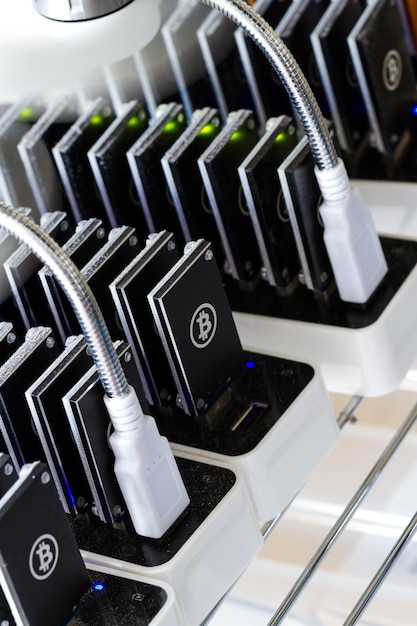Photo bitcoin mining usb devices in a row with small fans.