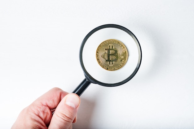 Bitcoin-munt door een vergrootglas