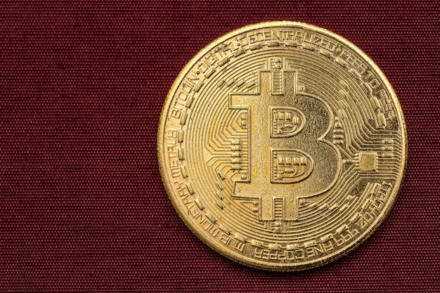 Bitcoin on a patterned maroon color background.