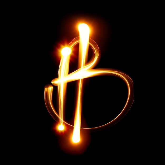 Bitcoin sign over black background. Light painting