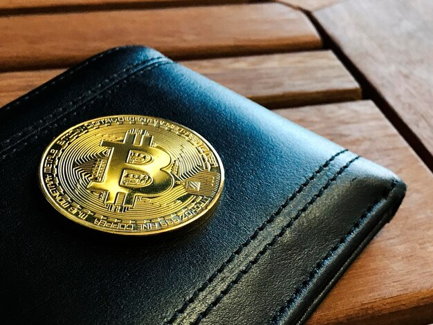 Bitcoin and wallet on wooden table