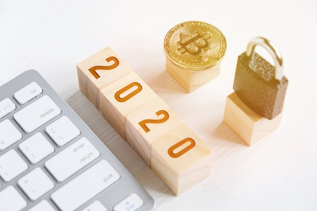 Bitcoin with numbers on cubes on a white wooden background with a keyboard and a lock. 