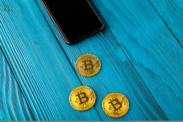 Bitcoin woman with mobile phone and golden coin and bitcoin in hands