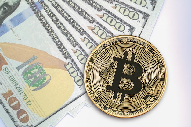 Moneta bitcoin e banconote americane da cento dollari primo piano di monete bitcoin criptate in metallo lucido e dollaro statunitense