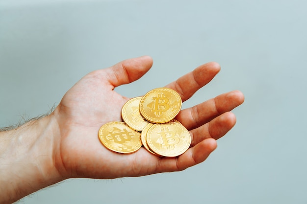 Bitcoins in hand on a light background high quality photo