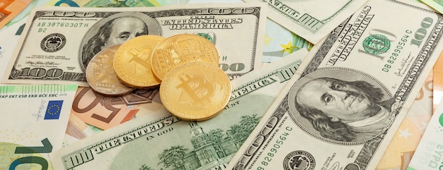 Bitcoins op een textuurachtergrond van euro en dollarspanorama