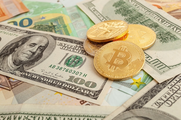 Bitcoins on a texture background of euro and dollars
