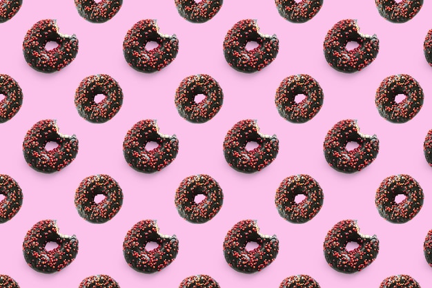 bitted donuts with glaze on pink background pattern Food dessert of sweet nibbles chocolate donuts