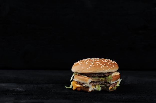 Bitten burger on a dark rustic