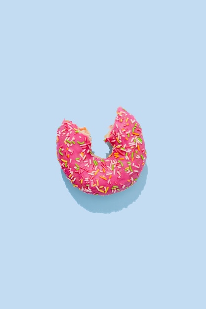 Bitten Donut in pink glaze with colorful sprinkles